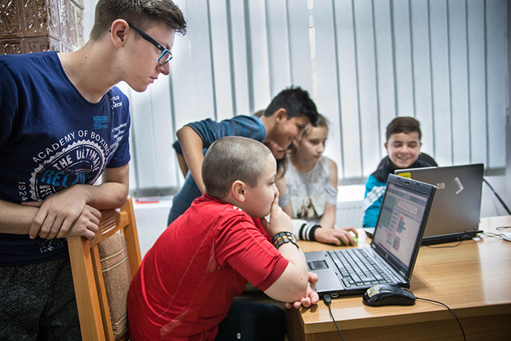 Photo of Un ambasador al codingului ajutând un membru al clubului
